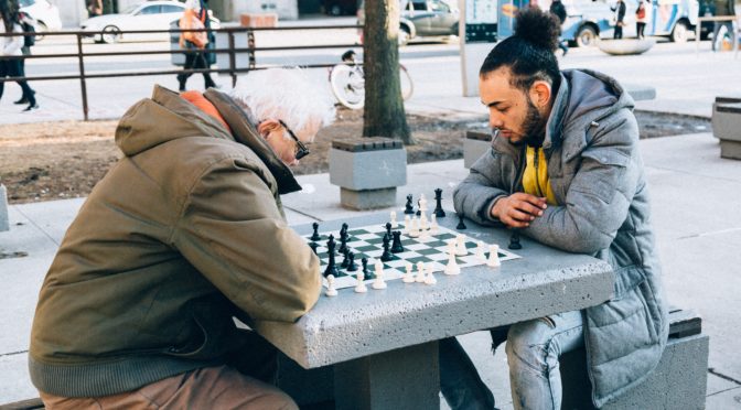 people playing chessboard game outdoor